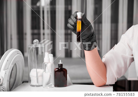 Female researcher in sterile gloves holding test tube. Female researcher in sterile gloves holding test tube. 78155583