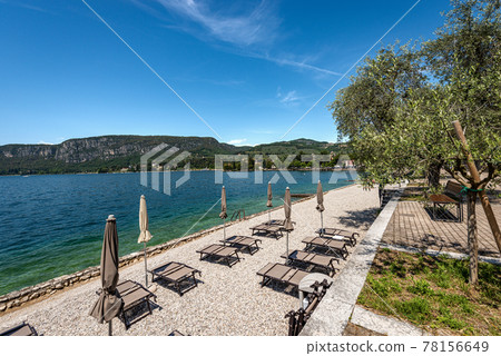 Beach Umbrellas and Empty Deck Chairs on Lake Garda - Veneto Italy 78156649