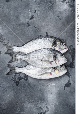 Raw three sea bream or Gilt head bream dorada fish on grey textured background, top view. 78156685