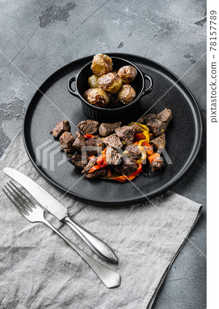 Meat stew with sweet bell pepper and bay leaf, on gray stone background 78157789