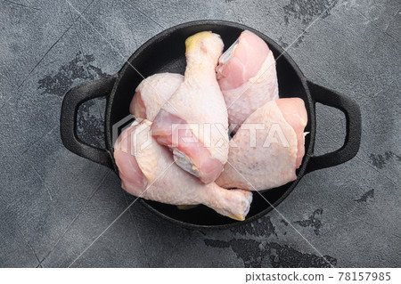 Fresh Chicken drumstick, in frying cast iron pan, on gray stone background, top view flat lay Fresh Chicken drumstick, in frying cast iron pan, on gray stone background, top view flat lay 78157985