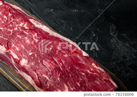 Fresh and raw beef meat. Whole piece of tenderloin with steaks, on black stone background, with copy space for text Fresh and raw beef meat. Whole piece of tenderloin with steaks, on black stone background, with copy space for text 78158006
