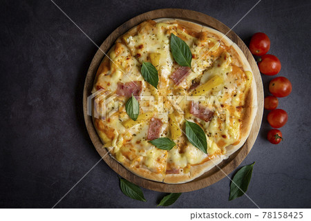 Tasty pizza homemade italian food style, pizza cheese ham and pineapple fruit cooking ingredients tomatoes basil on black background, Top view of pizza cheese italian food style. Flat lay Tasty pizza homemade italian food style, pizza cheese ham and pineapple fruit cooking ingredients tomatoes basil on black background, Top view of pizza cheese italian food style. Flat lay 78158425