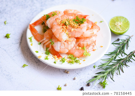Garlic shrimp peeled on white plate background dining table food, Fresh shrimps prawns seafood lemon lime with herbs and spice 78158445