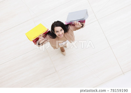 Smiling woman holding multicolored paper shopping bags top view Smiling woman holding multicolored paper shopping bags top view 78159190