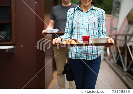 Woman and man are carrying food trays Woman and man are carrying food trays 78159289