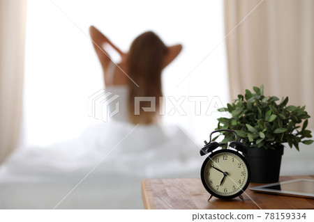 Woman stretching in bed after wake up, back view, entering a day happy and relaxed after good night sleep. Sweet dreams, good morning, new day, weekend, holidays concept 78159334