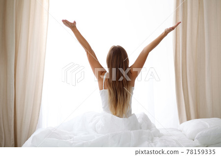 Woman stretching in bed after wake up, back view, entering a day happy and relaxed after good night sleep. Sweet dreams, good morning, new day, weekend, holidays concept Woman stretching in bed after wake up, back view, entering a day happy and relaxed after good night sleep. Sweet dreams, good morning, new day, weekend, holidays concept 78159335