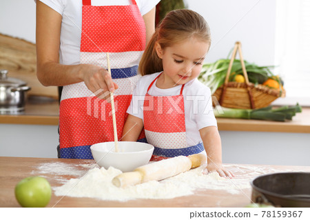 Happy woman and her daughter are kneading the dough and baking cookies for a delicious family feasting. Christmas, New year, Thanksgiving, Anniversary, Mothers Day. Healthy meal cooking concept Happy woman and her daughter are kneading the dough and baking cookies for a delicious family feasting. Christmas, New year, Thanksgiving, Anniversary, Mothers Day. Healthy meal cooking concept 78159367