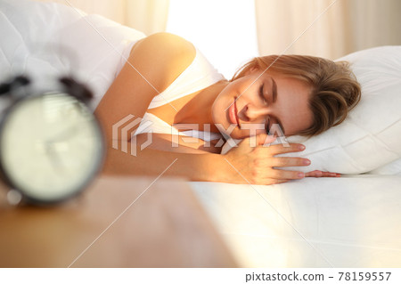 Beautiful blonde girl sleeping sweetly in sunny bedroom on a white bed. Holyday comfort and Rest concepts 78159557