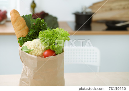 Interior of kitchen room with wooden table, big window and a paper bag full of fresh foods ready to cook. Template. Interior of kitchen room with wooden table, big window and a paper bag full of fresh foods ready to cook. Template. 78159630