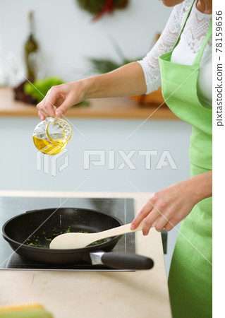 Unknown young woman frying meal at worm pan by new keto recipe while standing in the kitchen. Cooking and householding concepts 78159656
