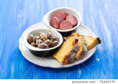 olives with smoked sausages and corn bread 78160145