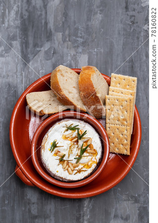 cheese with herbs, nuts and honey in ceramic dish 78160822