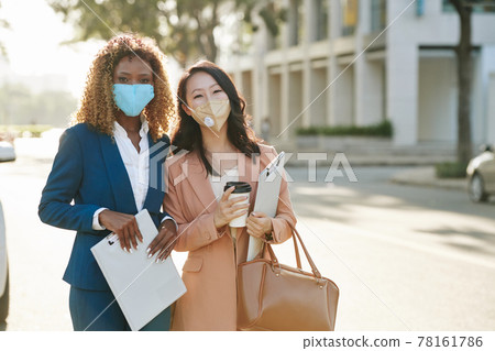 Cheerful businesswomen in protective masks 78161786
