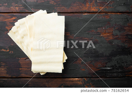 Organic lasagna pasta sheets, on old dark wooden table background, top view, flat lay, with copy space for text 78162654