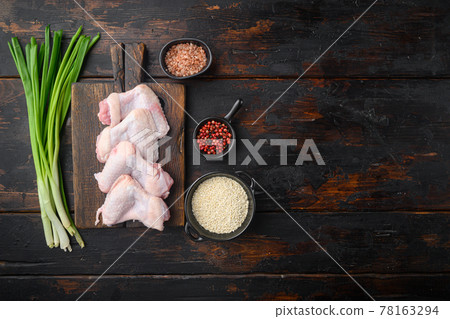 Fresh raw middle chicken wings with ingredients, and sesame, on wooden cutting board, on old dark wooden table , top view flat lay, with copy space for text Fresh raw middle chicken wings with ingredients, and sesame, on wooden cutting board, on old dark wooden table , top view flat lay, with copy space for text 78163294