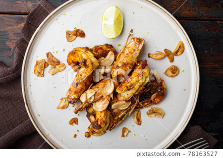 Grilled Mango Prawns or shrimps, on plate, on old dark wooden table background, top view flat lay 78163527