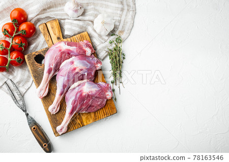 Raw duck leg thighs , with herbs and ingredients, on wooden cutting board, on white stone background, top view flat lay, with copyspace and space for text Raw duck leg thighs , with herbs and ingredients, on wooden cutting board, on white stone background, top view flat lay, with copyspace and space for text 78163546