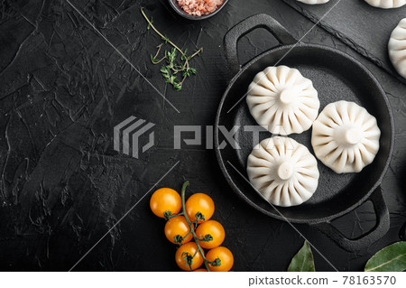 Raw dumplings Dim Sum, in frying cast iron pan, on black stone background, top view flat lay, with copy space for text Raw dumplings Dim Sum, in frying cast iron pan, on black stone background, top view flat lay, with copy space for text 78163570