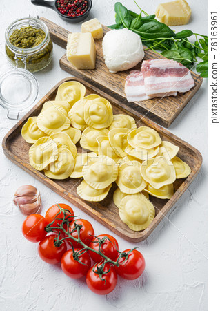 Italian Homemade ravioli with ingredients, ham, basil, pesto, mozzarella, on wooden tray, on white background 78163961
