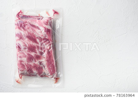 Vacuum packaging with raw pork rib, on white stone background, top view flat lay, with copy space for text 78163964