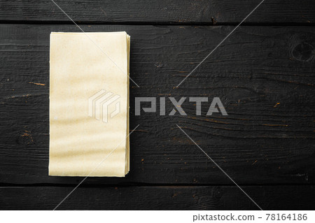 Dried uncooked lasagna pasta sheets, on black wooden table background, top view, flat lay, with copy space for text 78164186