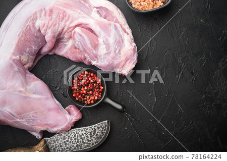 Raw rabbit meat with spice and ingredients, on black stone background, top view flat lay, with copy space for text Raw rabbit meat with spice and ingredients, on black stone background, top view flat lay, with copy space for text 78164224