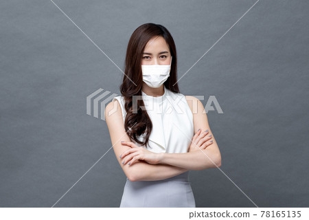 Young Asian woman in corporate wear with face mask crossing her arms 78165135