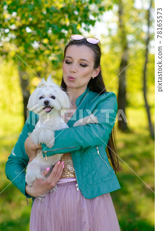Young girl with her dog. Puppy white dog is running with it's owner. Concept about friendship, animal and freedom. Young girl with her dog. Puppy white dog is running with it's owner. Concept about friendship, animal and freedom. 78165573