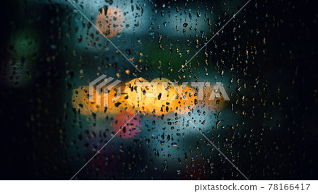 Rain drop on window at night. Condominium or apartment living room window on rainy season night in Bangkok Thailand. Outside window is blurred bokeh of raining city light and natural tree and sky. Rain drop on window at night. Condominium or apartment living room window on rainy season night in Bangkok Thailand. Outside window is blurred bokeh of raining city light and natural tree and sky. 78166417