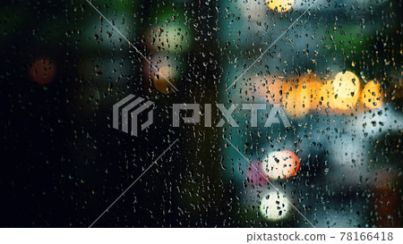 Rain drop on window at night. Condominium or apartment living room window on rainy season night in Bangkok Thailand. Outside window is blurred bokeh of raining city light and natural tree and sky. 78166418