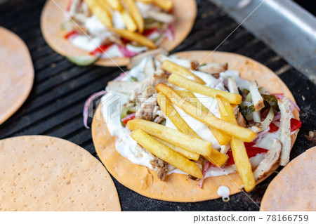 A delicious dish of meat and sauce with potatoes and vegetables on a bread cake. A delicious dish of meat and sauce with potatoes and vegetables on a bread cake. 78166759