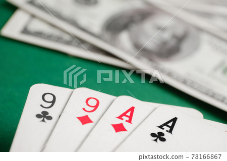 Two pair of aces and nines during poker with dollars on green table. Two pair of aces and nines during poker with dollars on green table. 78166867