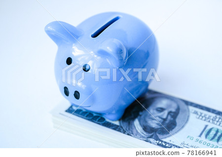 Blue piggy bank is standing on stack of hundred dollar bills. 78166941