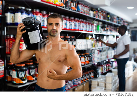 man holding cans of sports nutrition 78167192