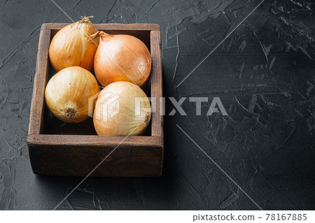 Unpeeled raw yellow onions, on black background with copy space for text Unpeeled raw yellow onions, on black background with copy space for text 78167885