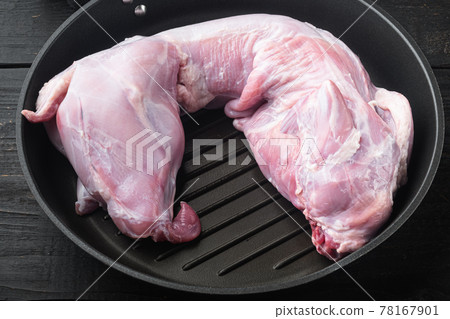 Fresh raw rabbit meat, in frying cast iron pan, on black wooden table Fresh raw rabbit meat, in frying cast iron pan, on black wooden table 78167901