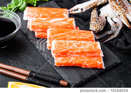 Fresh Crab meat surimi with blue swimming crab, on stone board, on black background Fresh Crab meat surimi with blue swimming crab, on stone board, on black background 78168059