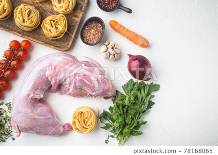 Raw rabbit meat with fresh vegetables ready for cooking, on white stone background, top view flat lay, with copy space for text Raw rabbit meat with fresh vegetables ready for cooking, on white stone background, top view flat lay, with copy space for text 78168065