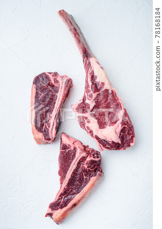 Dry aged Raw porterhouse beef meat Steak, tomahawk, t bone or porterhouse and club steak, on white stone background, top view flat lay Dry aged Raw porterhouse beef meat Steak, tomahawk, t bone or porterhouse and club steak, on white stone background, top view flat lay 78168184