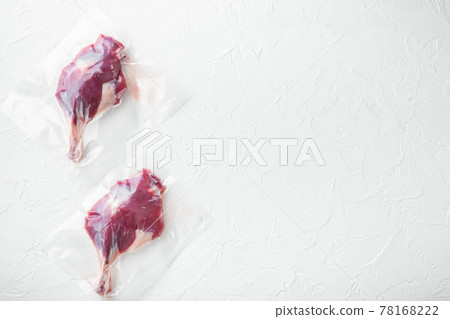 Vacuum packed raw duck leg, on white stone background, top view flat lay, with copyspace and space for text Vacuum packed raw duck leg, on white stone background, top view flat lay, with copyspace and space for text 78168222