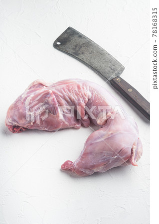 Whole rabbit meat, and old butcher cleaver knife, on white stone background 78168315