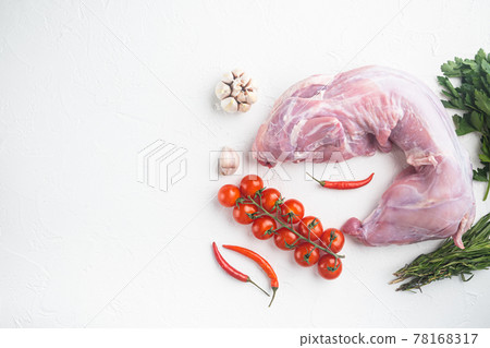 Fresh raw rabbit with olive oil, rosemary, peppers, sea salt, onion, on white stone background, top view flat lay, with copy space for text 78168317