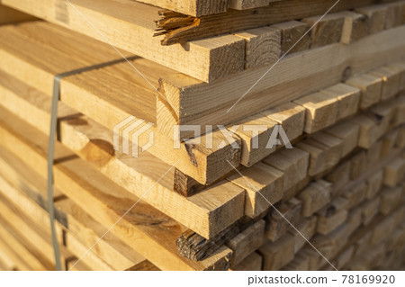 Storage of piles of wooden boards on the sawmill. Boards are stacked in a carpentry shop. Sawing drying and marketing of wood. Pine lumber for furniture production, construction. Lumber Industry. Storage of piles of wooden boards on the sawmill. Boards are stacked in a carpentry shop. Sawing drying and marketing of wood. Pine lumber for furniture production, construction. Lumber Industry. 78169920
