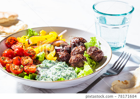 Greek food concept. Meatballs, tzatziki sauce, tomato and cucumber salad. Greek food concept. Meatballs, tzatziki sauce, tomato and cucumber salad. 78171684