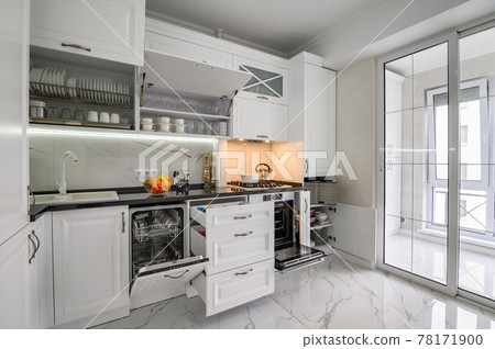 Luxurious white modern kitchen interior, drawers pulled out, dishwasher's door open Luxurious white modern kitchen interior, drawers pulled out, dishwasher's door open 78171900