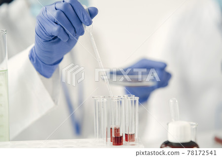 Laboratory worker studying blood samples to detect pathologies 78172541