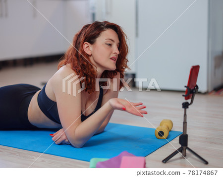 Fit Young Woman Excersising At Home, Watching Video Tutorial On smartphone Fit Young Woman Excersising At Home, Watching Video Tutorial On smartphone 78174867