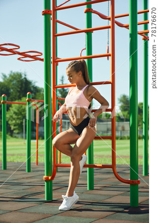 Sexy sportswoman posing at sports ground. 78176670